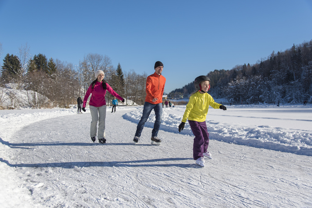 Eislaufer beim Winterspaß am Aichwaldsee in der Region Faaker See